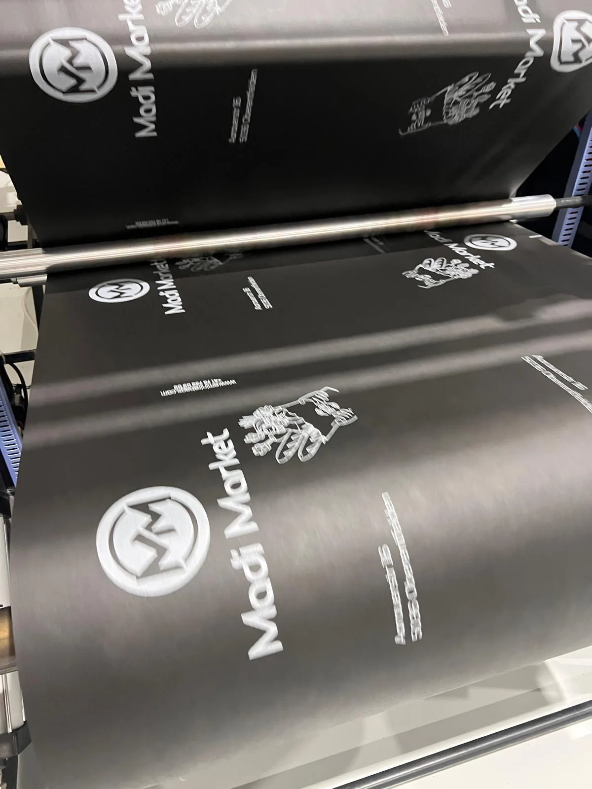 Printed material moving through factory rollers